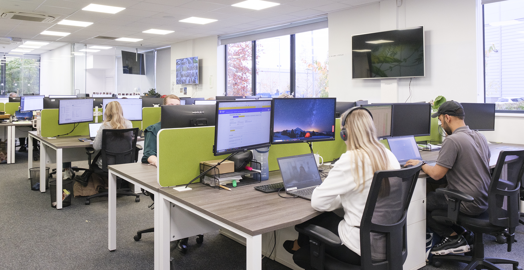 Managed detection and response experts working in an open plan office on laptops